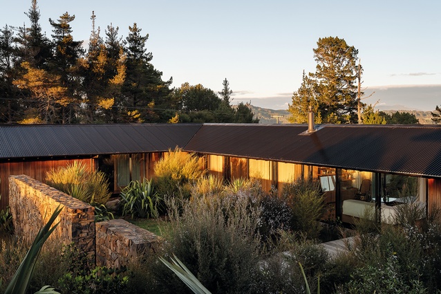 The green courtyard is framed by the house’s two wings and the wall built by Coroglen stonemason Mark Ulrich.