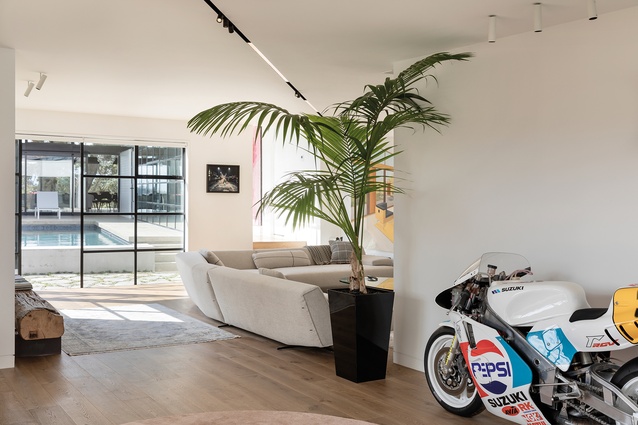 The re-imagined entrance hall is like a gallery where visitors can pause to take in the ‘artwork’: a restored Grand Prix motor bike. In a lounge sits the Panca bench and Sydney corner sofa from Poliform, both available from Studio Italia.