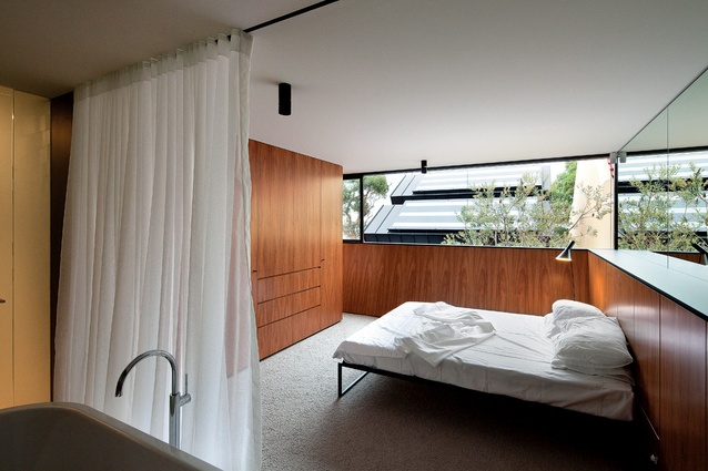 The timber-lined master bedroom with low walls angled out to "scoop in the sun."