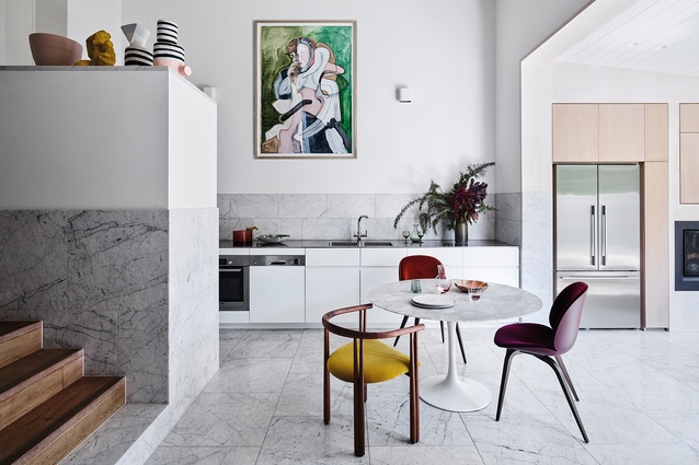 The addition of Carrara marble tiles in the kitchen brings a sophisticated edge. A Tulip dining table, designed by Eero Saarinen and produced by <a 
href="https://www.knoll.com/shop/by-category/knoll-classics/the-eero-saarinen-collection"style="color:#2250e5"target="_blank"><u>KnollStudio</u></a>, is surrounded by an eclectic mix of chairs.