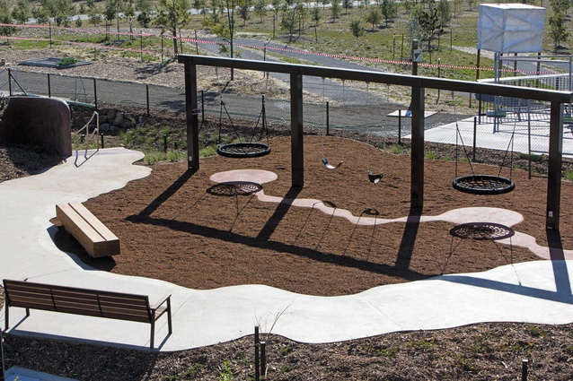 A swing set surrounded by meandering pathways.
