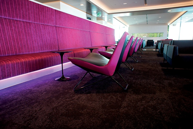 The overall colour palette is neutral, with accent colour Bold Violet appearing in key upholstery, LED lighting and digital imagery throughout the wider space.