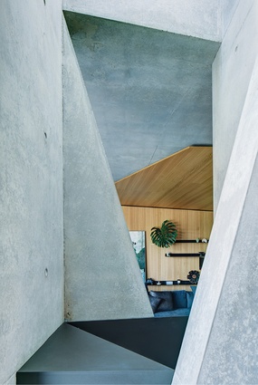 The sharp geometry of the architecture continues inside, where canted walls playfully obscure views between rooms.