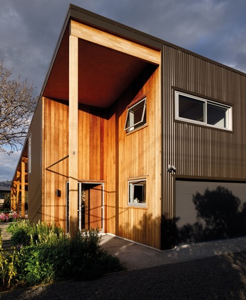 The front entrance features a recessed porch clad in New Zealand redwood.
