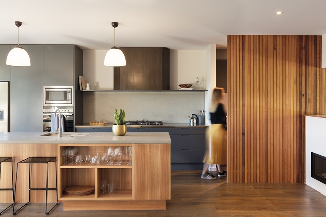 The designers note that the concrete bench and splashback in the kitchen were chosen to keep the interior finishes consistent with the exterior architecture.