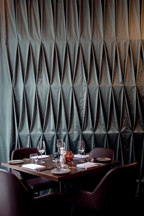 The diamond-shaped design of the restaurant's bespoke curtain reflects the geometric forms of the restaurant bottle display, a garden trellis and arbour.