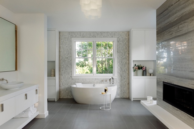 The large bathroom was completely refurbished to include a stone fireplace, a free-standing tub and some shelving with space to display objects and flowers.