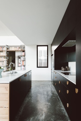 Burnished concrete floors and black cabinetry make for a modern kitchen. 
