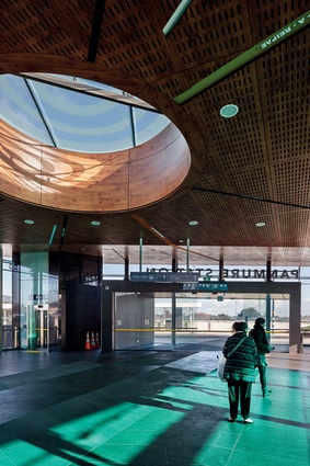 An oculus in the perforated laminate ceiling pools light in the centre of the concourse, while coloured glazing adds light and warmth to the building’s interior. 
