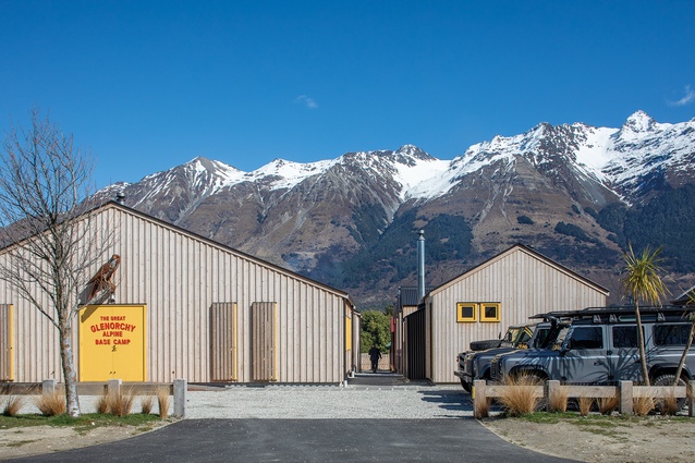 Street elevation of the The Great Glenorchy Alpine Base Camp, with the ‘Communal Barn’ at left, accommodation huts at right, and mountain peaks of the Humboldt Range in the background.