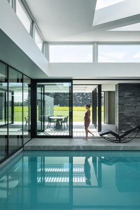 The home surrounds an internal swimming pool, which reflects natural light into the rest of the space.
