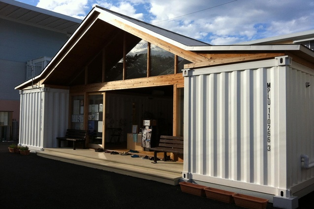 Ban’s community center is a large pitch-roofed space with amenities tucked into shipping containers.