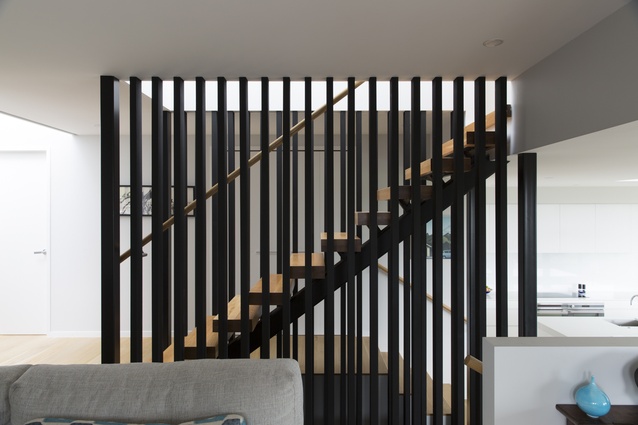 A sculptural staircase stands at the centre of this ‘new house renovation’, reinforcing the bold lines of the architecture.