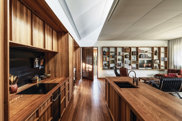 Sensually rich in its material palette, the main living space is illuminated by a full-width, angled skylight.
