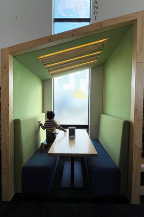 A child peers out the window from one of the cozy study booths.
