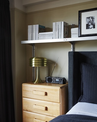 Wherever possible, storage and display space is provided, such as the industrial E-Z Shelving System above the bed. 