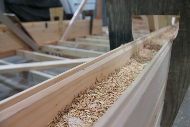 A mix of agricultural byproducts and mycelium (mushroom roots) fills the cavity between two wood panels where it will develop into an eco-friendly insulation. 