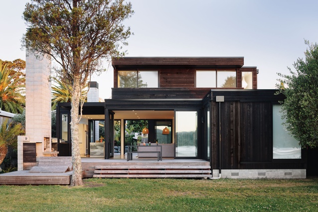 The house is clad with stained cedar and black Colorsteel.