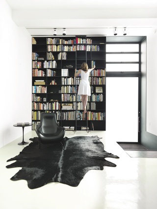 The light-filled space is defined by a full-height bookcase made from 10 mm steel.