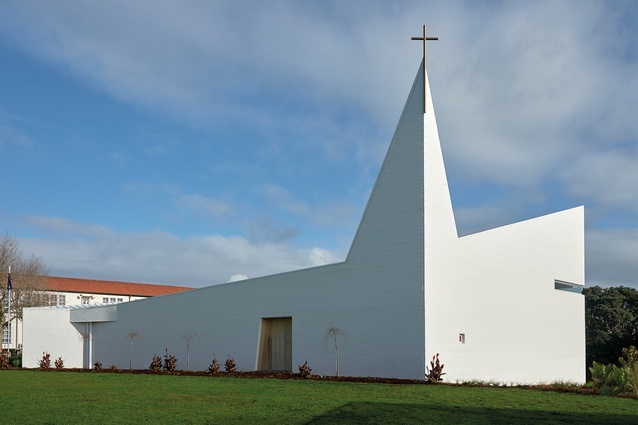 The triangular white brick spire is seamlessly fused with the eastern corner walls.