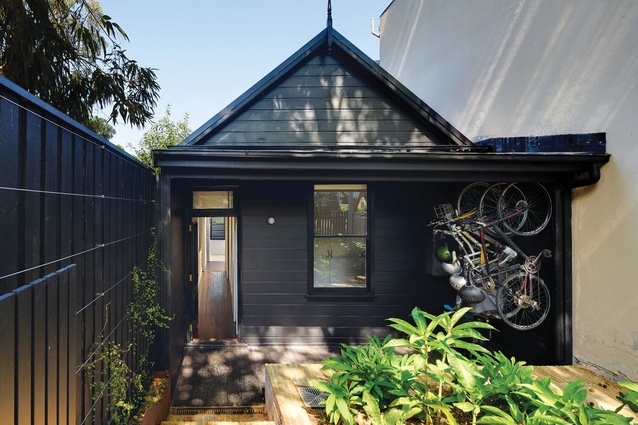 The “heritage” weatherboard frontage has been painted black to suppress non-original details and materials.