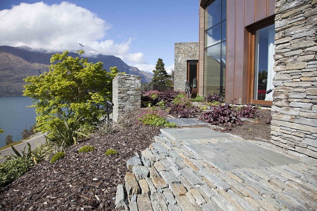 A boulder pathway winds around the property with interspersed planting. 