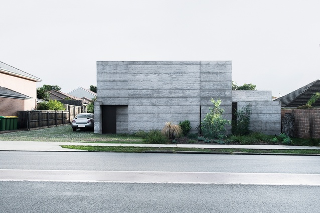 The monolithic form defends against noise and presents a counterpoint to typical suburbia.