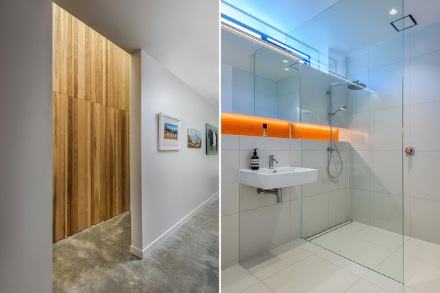 At the entry, a timber wall conceals the door to the bathroom, which is almost entirely white barring a pop of orange.