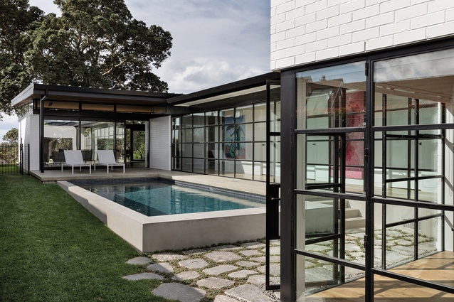 The pool is treated as a separate aesthetic volume, rising out of the ground. <a 
href="https://www.studioitalia.co.nz/products/landscape4"style="color:#3386FF"target="_blank"><u>Landscape Via loungers</u></a> from Kettal sit just off to the side. Because of the varied angles between the existing house, the bedroom wing and the pavilion/pool, Helleur opted for organically shaped pavers.