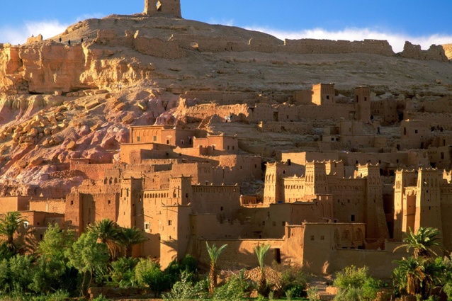 Aït Benhaddou in southern Morocco is an example of an <em>ighrem</em> (fortified village). The village consists of a range of crowded earthern clay dwellings surrounded by high defensive walls, reinforced by angle towers.