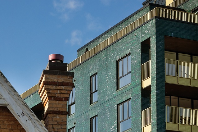 The uneven green-brick surface adds to the contextual fabric of the local area.