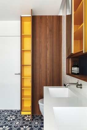 Bright-yellow interiors are a colourful surprise hidden inside the bathroom joinery.