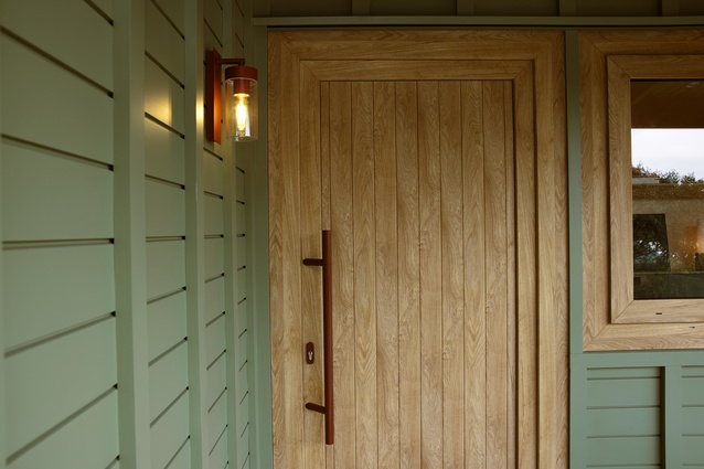 The front entry with matching scoria red door handle and light details.