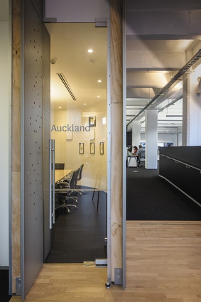A meeting room door inserted between overlapping screened walls.