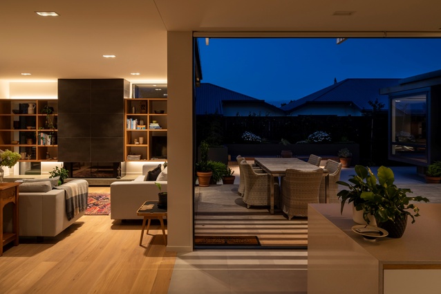 Pivot House. The kitchen at night looking onto the main courtyard and outdoor living area.