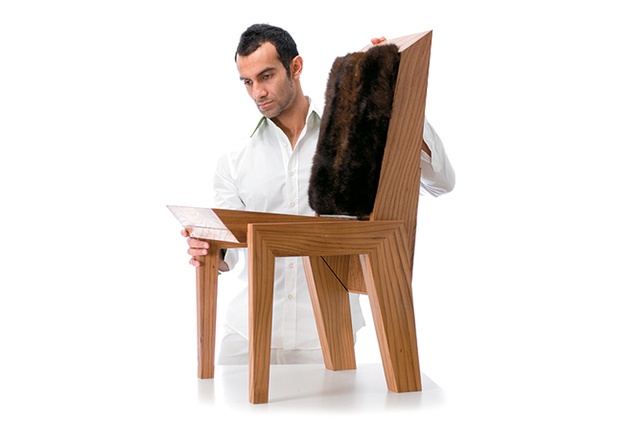 Khalid Shafar standing next to the Gemini chair which combines a luxurious possum fur seat with an angled timber base.