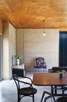 The rammed-earth wall provides contrast to the plywood lining.