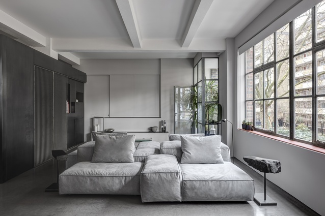The pared-back colour palette layers greys, whites and metallics. A generously scaled sofa takes centre stage. 