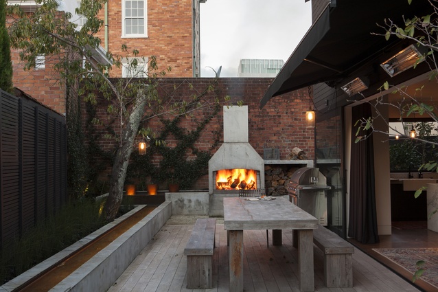 The dining room of the new house opens on to a courtyard with an outdoor fireplace.