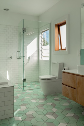 The bathroom hosts three different tiling shapes, creating an interesting yet subtle patterned effect.