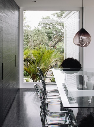 A glass-topped table and acrylic chairs recede from view, allowing the greenery to come to the fore.