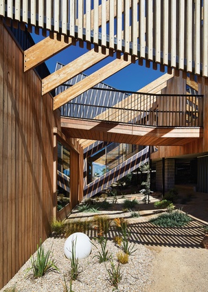 The pavilions are stitched together by pergola beams, a walkway to the roof deck and an enclosed staircase, creating layers of diagonal lines.