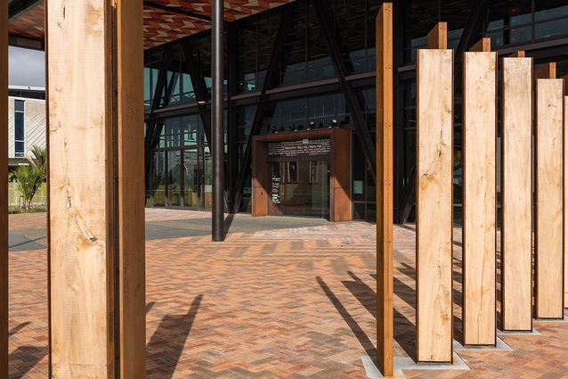 A Corten steel and timber screen separates visitors in the ātea from vehicles in the car park.