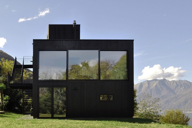 This charred timber holiday home is a prototype built in 2014 next to Lake Maggiore, Italy, to demonstrate the possibilities of prefabricated wood panel construction methods.