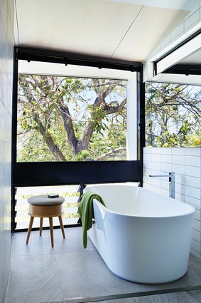 A low bank of louvres in the main ensuite allows for ventilation, while fixed glazing above frames the treetop view.