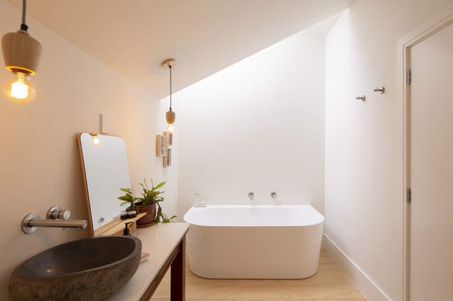  A material palette of pale timbers and white surfaces and walls provides a sense of softness in the bathroom.