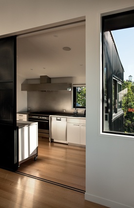 The modern, stainless steel kitchen can be hidden from view behind sliding panel doors.
