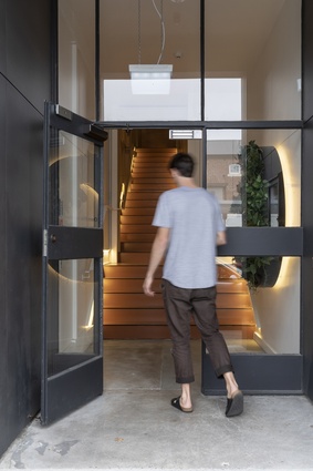 Warm lighting on the stair entices visitors from the street. 