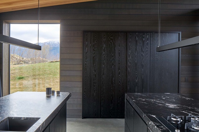 A rustic look is provided by a wall of timber weatherboards at the end of the open plan space.