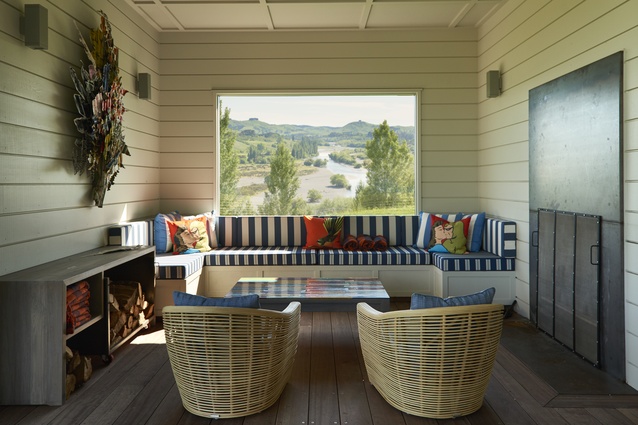 The verandah snug is a riot of colour, set in motion by a corrugated steel Jeff Thomson work. Striped and tweed outdoor fabrics from Westbury on built-in seating and cane Global chairs (Design Warehouse), set off with Dick Frizzell cushions. 